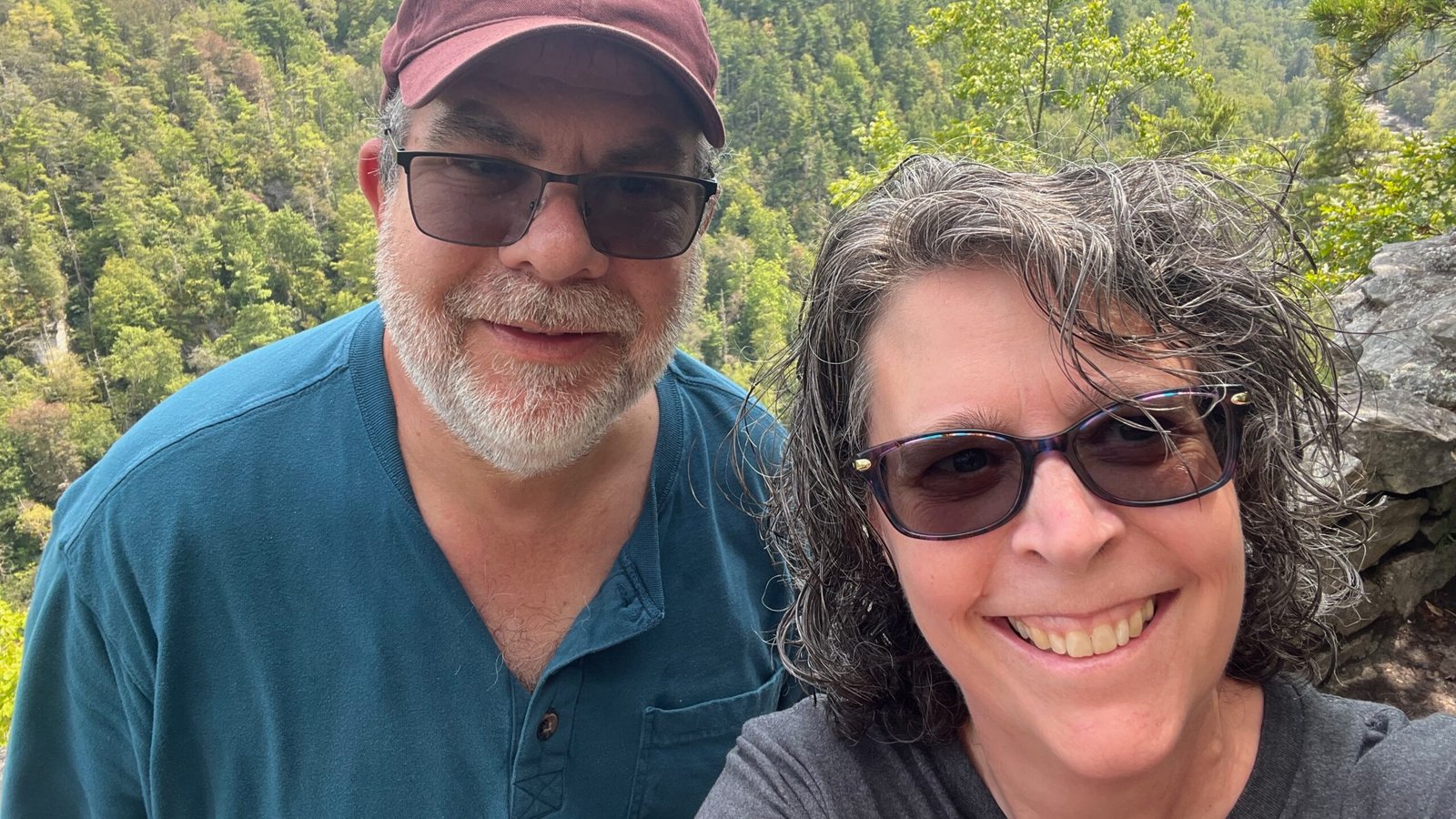 Hilarie Cox Hiking Hilarie Cox and her husband smiling together during a mountain hike.
